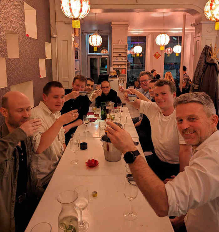 Kolleger løfter glassene ved en fællesmiddag